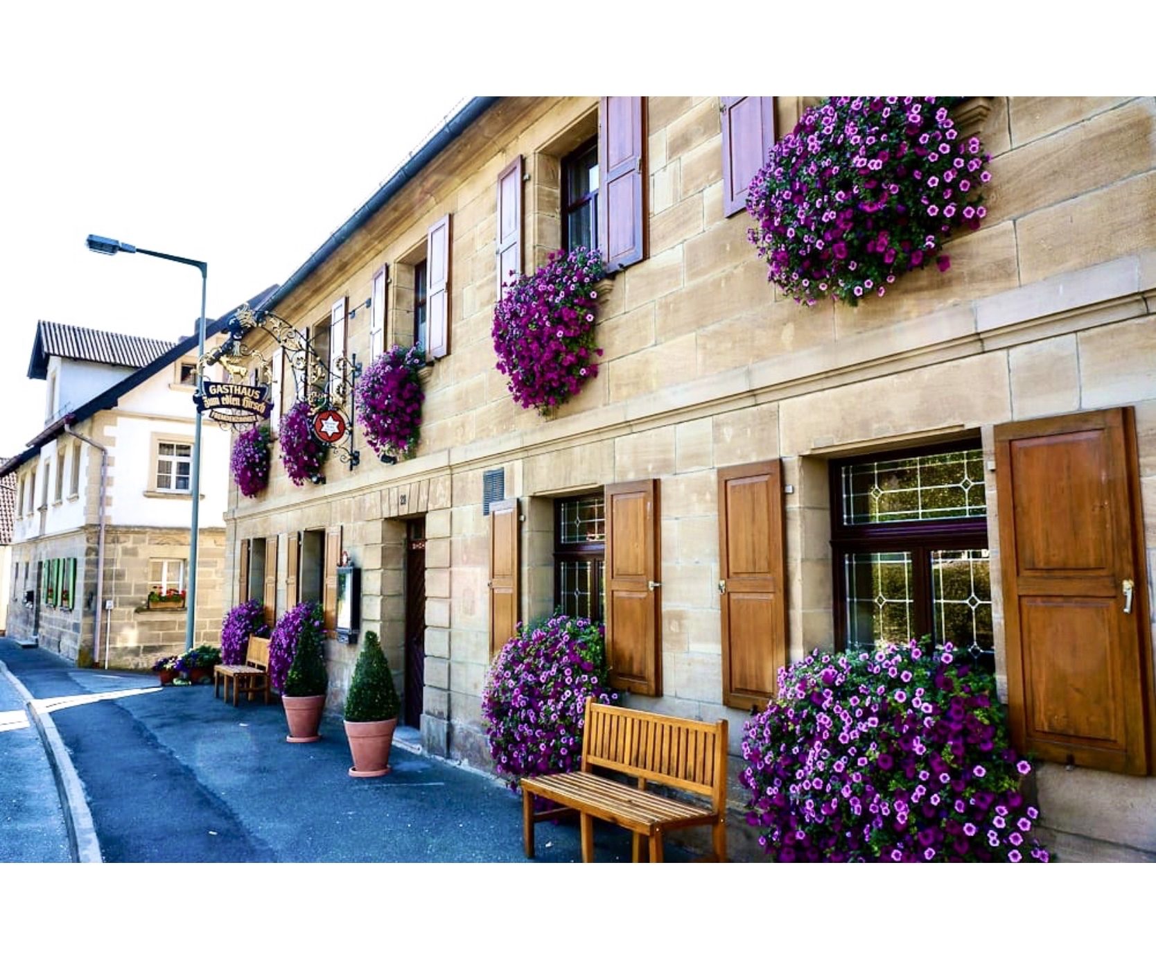 Fassade des Gasthaus zum edlen Hirsch in Seybothenreuth mit blühenden Blumenkästen